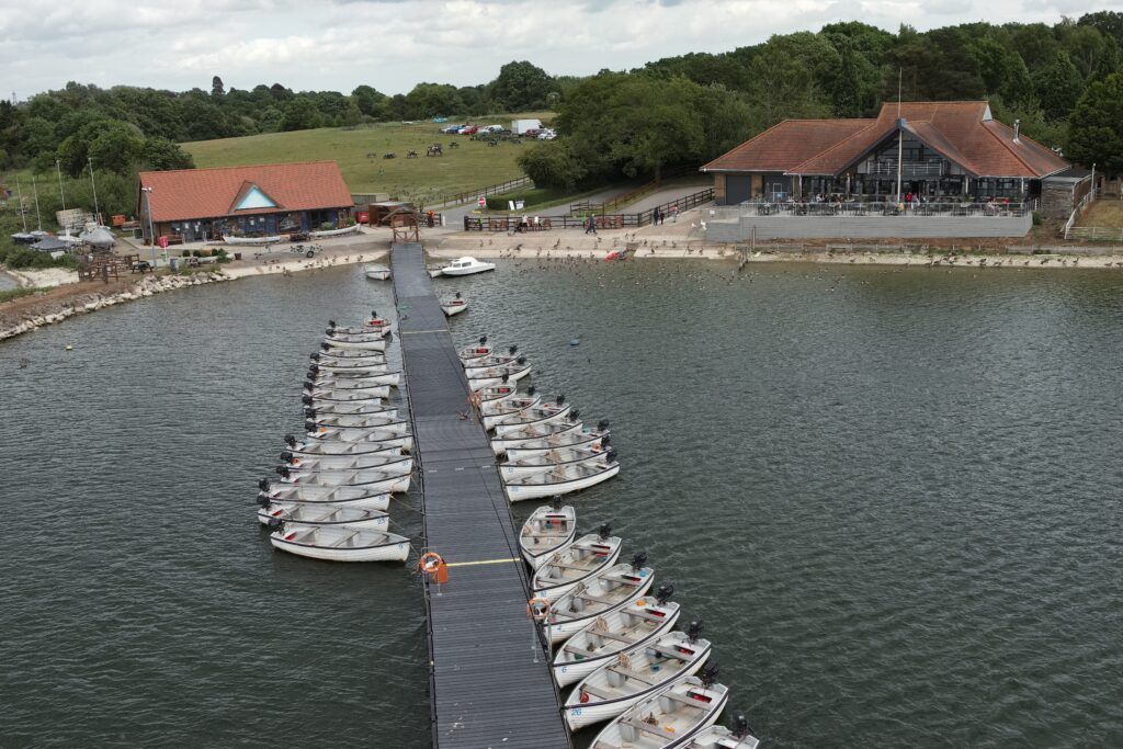 Ariel view of Hanningfield Waterside Park including boats on the jetty, fishing lodge and cafe on the water